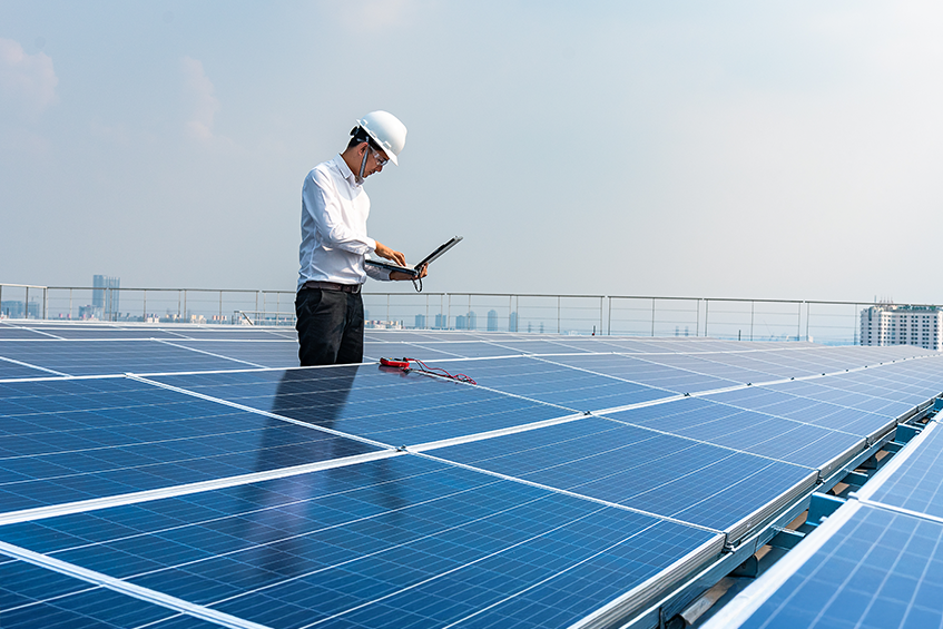 asian man on computer among solar panels